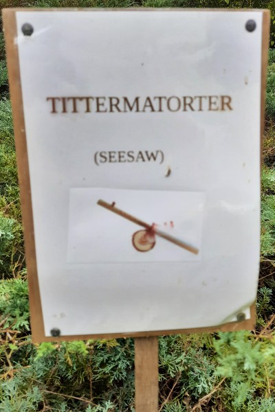 Photograph of a laminated sign reading 'Tittermatorter,' along with a clipart image of a see-saw