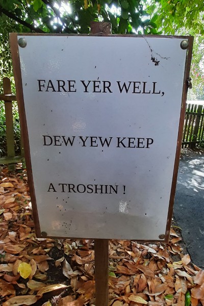Photograph of a laminated sign reading 'FARE YER WELL, DEW YEW KEEP A TROSHIN!